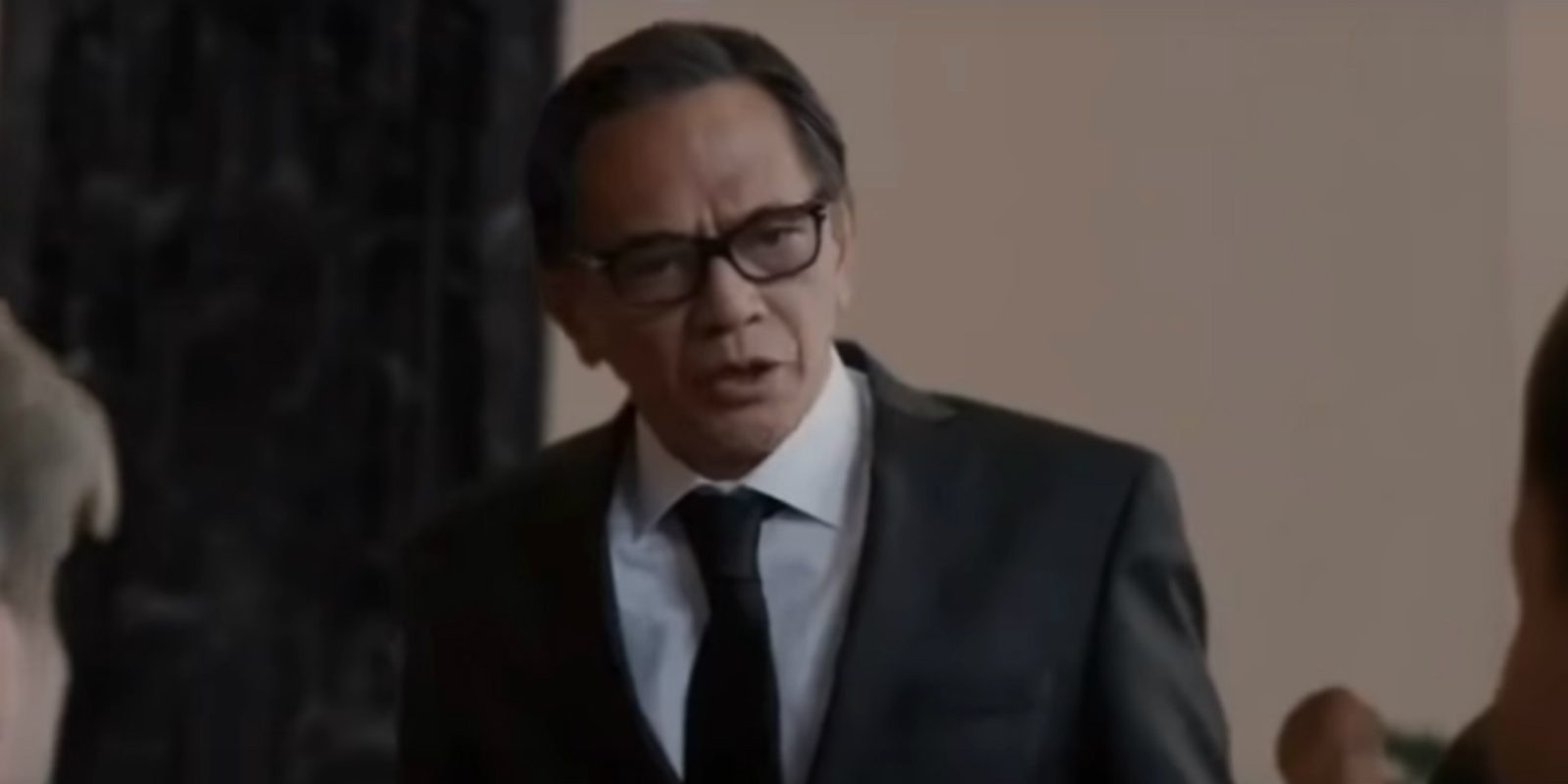 Ray Sahetapy menggunakan kaca mata dan setelan jas menjadi seorang ketua lelang